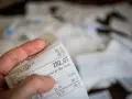 Dłoń trzyma paragon z widoczną kwotą 282,07 zł.
