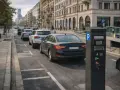 Parkomat przy ulicy, gdzie samochody czekają w kolejce. Opłata za parkowanie wynosi euro 5.
