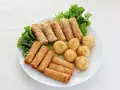 Talerz z sajgonkami, kulkami ryżowymi i warzywami, idealny do przepisów z House of Asia.