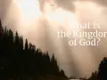 Sunlight streams through clouds over a dark forest, illuminating the question: "What Is the Kingdom of God?