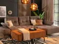 Elegancki salon z sofą w kolorze taupe, który jest pięknym odcieniem brązu z szarym akcentem. Wygodny narożnik i pufa tworzą przytulną przestrzeń.