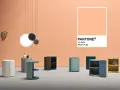 Arredamento moderno su sfondo color pesca Pantone. Tavolini cilindrici e un telefono vintage.