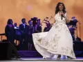 Aretha Franklin w białej sukni z haftem, śpiewa na scenie z chórem. Jej dzieci z pewnością byłyby dumne.