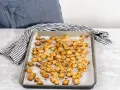 Una teglia piena di crostini di pane dorati e croccanti, conditi con erbe aromatiche. Perfetti per insalate o zuppe.