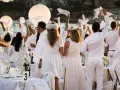 Festa in bianco: tutti vestiti di bianco per un evento elegante sulla spiaggia. Un'atmosfera magica con palloncini luminosi e tavoli apparecchiati.