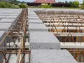 Budowa stropu gęstożebrowego: widoczne pustaki keramzytowe i zbrojenie tworzące żebra rozdzielcze.