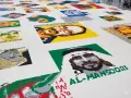 Portraits de personnalités réalisés en briques Lego, dans le style d'Ai Weiwei. L'œuvre est étendue sur un sol blanc.