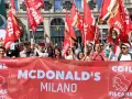 Manifestanti con bandiere rosse chiedono un miglior stipendio McDonald's a Milano.
