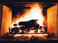 Legna che arde in un camino, con fiamme vivaci e un buon tiraggio presa aria camino che alimenta il fuoco.