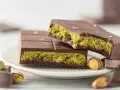 Schokolade mit Pistazienfüllung, die an Dubai Schokolade selber machen erinnert. Goldflocken verzieren die dunkle Schokolade.