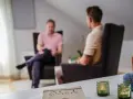 Två män i samtal i en lugn miljö. En bok om acceptance and commitment therapy svenska ligger på bordet.