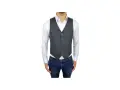 Uomo con camicia bianca, jeans e il panciotto francese grigio, un look elegante ma casual.