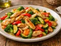 Salteado de pollo con verduras: trozos de pollo dorado con brócoli, pimientos rojos, calabacín y zanahoria.