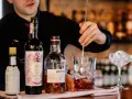Barman miesza składniki na klasycznego Manhattan drinka. Obok butelki whisky Aberlour i Martini Riserva Speciale Rubino.