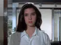 Młoda Jennifer Connelly w białej koszuli, z charakterystycznym spojrzeniem, jak z jej wczesnych filmów.