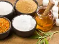 Schalen mit Zucker, Honig, Pollen und Stevia-Blättern – ideale Zutaten für zuckerersatz zum Backen.