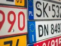 Un'opera d'arte di targhe automobilistiche europee, con numeri rossi e neri su sfondi bianchi e gialli.
