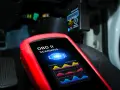 Un tecnico usa uno scanner OBD II per analizzare i dati dell'ECU dell'auto, mostrando grafici di sistema.