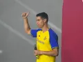 Cristiano Ronaldo w koszulce Al Nassr z mikrofonem, pokazuje kciuk w górę.