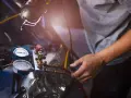 Mechanik sprawdza manometry układu klimatyzacji. Objawy zatarta sprężarka klimatyzacji mogą być widoczne na wskaźnikach.