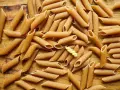 Makaron pełnoziarnisty penne i jeden skręcony makaron. Wybór między makaronem soba a pełnoziarnistym.