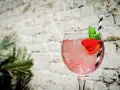 Orzeźwiający pink gin z lodem, truskawką i miętą, idealny na letnie popołudnie.