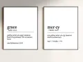 Two framed prints define "grace" as unmerited favor and "mercy" as not getting what you deserve, illustrating the contrast between grace vs mercy.