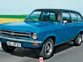 Niebieski Opel Ascona w wersji kombi jedzie po drodze, za nim pola i niebo.