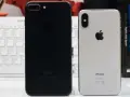 Dwa telefony iPhone: czarny i srebrny iPhone X.
