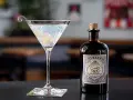 Klasyczny gin martini przepis z Monkey 47. Elegancki kieliszek z drinkiem i butelka ginu na blacie.
