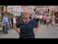 Kobieta w grochy na targu, gdzie kręcono miłość jest blisko. W tle tłum ludzi i kolorowe budki.