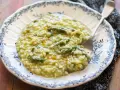 Un cremoso risotto agli asparagi, servito in un piatto decorato, pronto per essere gustato.