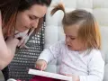 Mama czyta dziecku, a maluch odkrywa świat przez książkę, tworząc własne neologizmy dziecięce.
