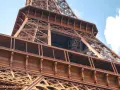 La famille Eiffel, une fortune bâtie sur le fer. Vue rapprochée de la Tour Eiffel, structure métallique complexe sous un ciel bleu.