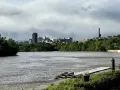 A cloudy sky looms over the Richmond, VA skyline, with the James River in the foreground. This view hints at fun things to do in Richmond, VA, like kayaking or enjoying the riverfront.