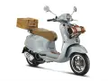 Stylowe skutery retro 125 w kolorze błękitnym, z wiklinowym koszem z tyłu i kocem z przodu, idealne na piknik.