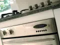 Edelstahl-Backofen mit digitaler Zeitanzeige (13:04). Die Knöpfe für Funktion und Temperatur sind sichtbar. Bereit für den ersten **Backofen einbrennen**.