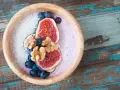Smoothie bowl z figami, borówkami i wiórkami kokosowymi, przypominający wyglądem tradycyjny kisiel.