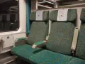 Wnętrze wagonu 4 Pendolino. Widok na dwa rzędy siedzeń z charakterystycznym wzorem.