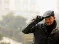 Will Smith, con un berretto uomo, giacca di pelle e sciarpa, saluta con un sorriso.
