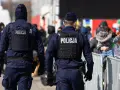 Dwóch policjantów w kamizelkach taktycznych pilnuje porządku. Chcesz wiedzieć, co trzeba zrobić, żeby zostać policjantem?