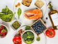 En hälsosam måltid med lax, bär, grönsaker och nötter. Denna inflammation mat är rik på omega-3 och antioxidanter.