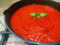 Sugo al pomodoro fresco e profumato, con foglie di basilico che galleggiano in una padella di ghisa.