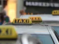 Reihe von Taxis mit gelben Dachschildern. Die aktuellen Taxipreise sind auf den Schildern nicht sichtbar, aber die Fahrzeuge stehen bereit.