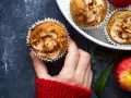 Hand hält einen frisch gebackenen Apfelmuffin, bestreut mit Zimt. Ein tolles Apfelmuffins Rezept!