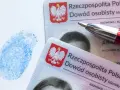Dwa polskie dowody osobiste, niebieski odcisk palca i czerwone pióro. Dokumenty są kluczowe w procesie uzyskania serii dowodu osobistego.