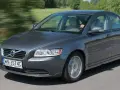 Szary Volvo S40 2.0 diesel w ruchu, z rozmazanym tłem zieleni i drogi.