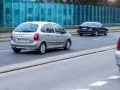Srebrny Citroën Xsara Picasso jedzie po drodze, mijając inne samochody.