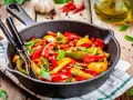 Peperoni in padella, colorati e succosi, pronti per essere gustati. Un contorno semplice e saporito.