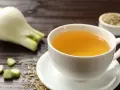Una taza de infusión de hinojo por la noche, con hinojo fresco y semillas esparcidas.